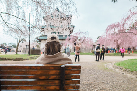 Woman tourist sightseeing Hirosaki Castle with Sakura Cherry Blossom in Spring, happy traveler...