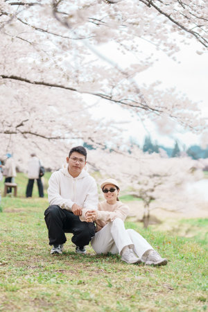 Couple tourist sightseeing Sakura Cherry Blossom in Spring. Happy traveler travel near Hinokinai...