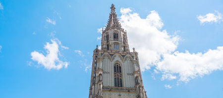 Bern Cathedral Minster tower rising above historic Old Town street in capital city of Switzerland, UNESCO World Heritage Site, famous medieval gothic architecture and Europe travel destination
