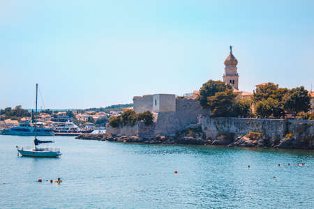 Krk Island, Croatia - July 19 2018: Picturesque coastline in Krk town on the island Krk. People are swimming in front of the old town.のeditorial素材