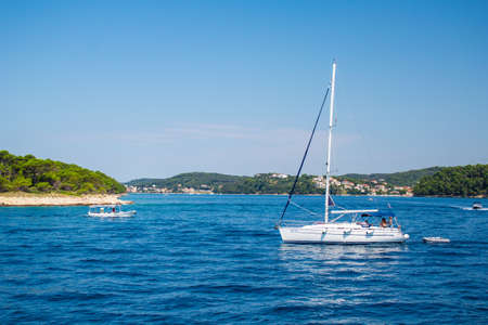 Rab Island, Croatia - July 20 2018: Sailing boats in front of Rab Island. Picturesque coastal scenery in summer.のeditorial素材