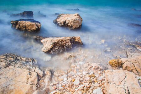 Rocks and waves at a pebble beach near Novalja town on Pag island in Croatiaの写真素材