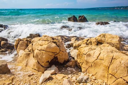 Rocks and waves at a pebble beach near Novalja town on Pag island in Croatiaの写真素材