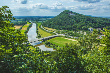 Emperor William Monument on top of Wittekindsberg and the Weser river on the left. Near the city of Porta Westfalica, North Rhine Westphalia, Germany. View from Portakanzel viewpoint.の写真素材