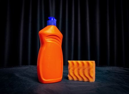 orange sponge with cleaning agent on black backgroundの写真素材