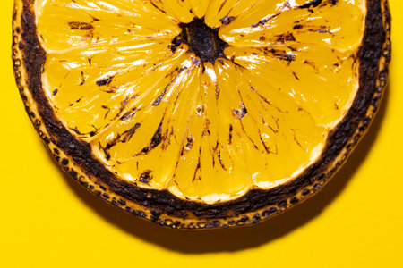 Roasted lemon slice isolated on yellow background.の写真素材