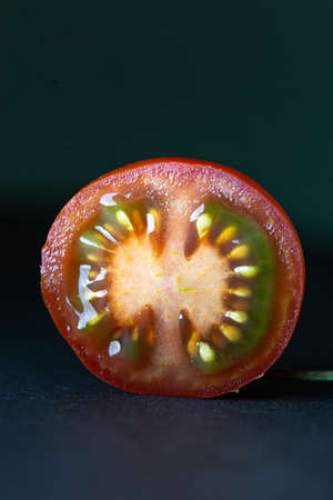 sliced tomato isolated on black background.の写真素材