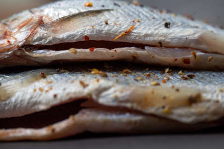 marinated fish belly with spices for cooking close-up.の写真素材