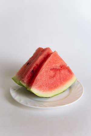sliced watermelon on a plate isolated on white background.の写真素材