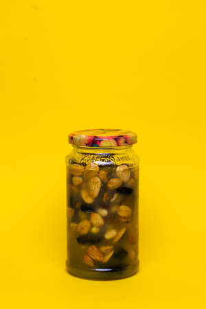 healthy food dishes nuts with honey. jam from nuts in a jar on a yellow backgroundの写真素材