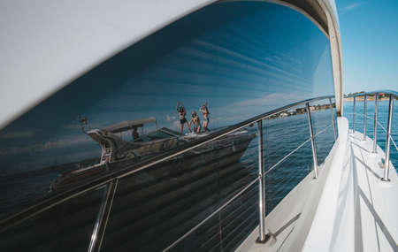 Photo of reflection in the window of yahda with girls at sea.の写真素材