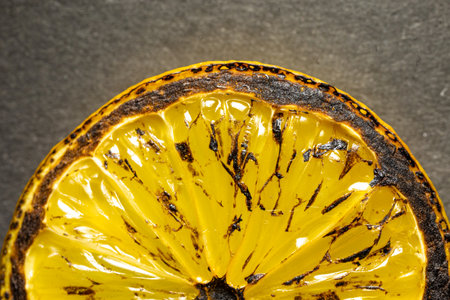 roasted lemon Juicy lemon slice on a gray background close-up.の写真素材