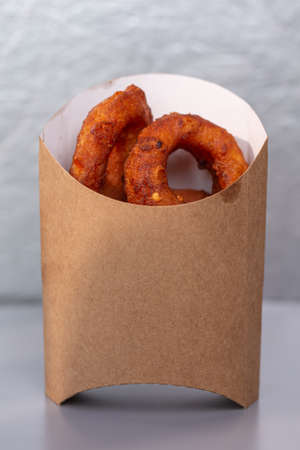 onion rings in a cardboard bag on a gray background.の写真素材