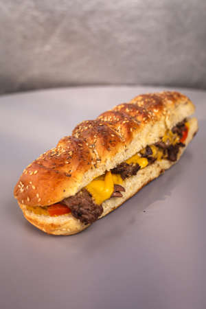 sandwich in a loaf with sesame seeds on a gray backgroundの写真素材