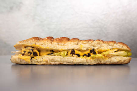 bun with cheese and meat on a gray background. Fast food.