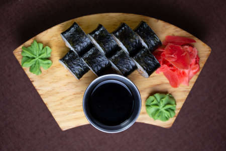 rolls with tuna, sauce and wasabi on a wooden standの写真素材