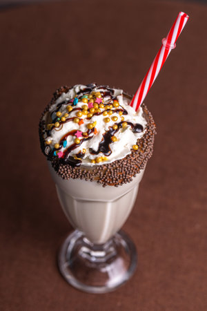 sweet milkshake with a tube on a brown background.の写真素材