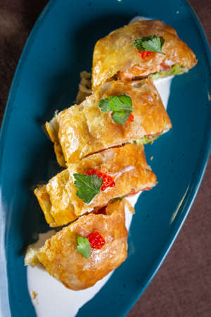 puff pastry roll with fish filling on a plateの写真素材