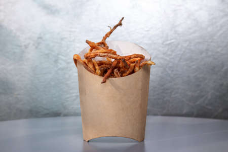 smoked fried cheese in a paper box on a gray background.