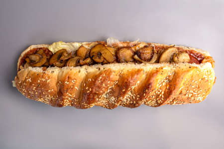 sandwich in a bun with sesame seeds with mushroom filling.