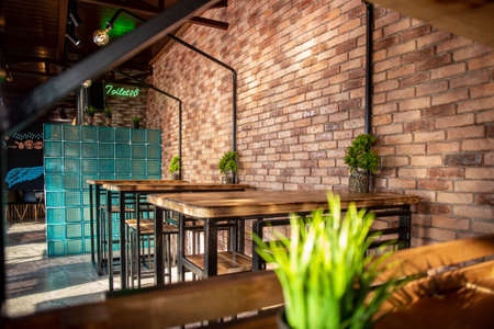 tables in a roadside cafe with a brick interior.のeditorial素材