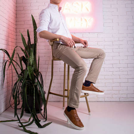 guy dressed in casual against the background of a white brick wall.の写真素材