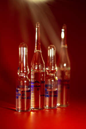 vials for vaccination against the virus on a red background.