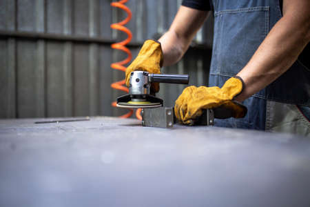 hands work grinder tool on a metal surface.の写真素材