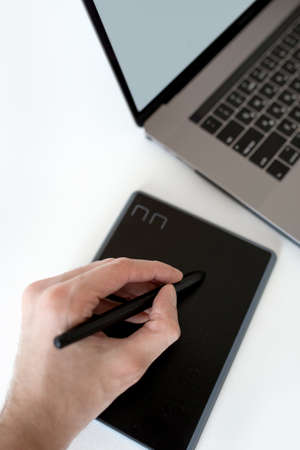 men's hand draws on black graphics tablet