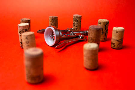 corkscrew and wine corks on a red backgroundの写真素材