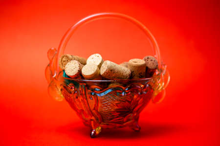 wine corks in a glass vase on a red backgroundの写真素材