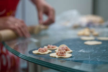 the process of making homemade dumplings in the kitchen.の写真素材