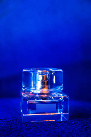 glass perfume bottle on a blue background.の写真素材