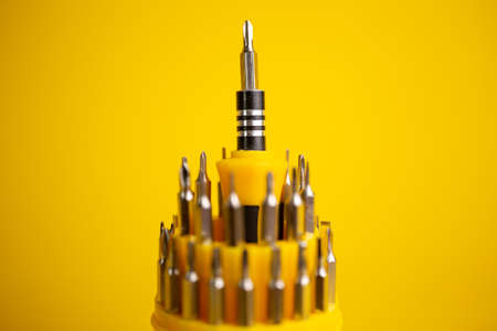 a set of screwdrivers for work on a yellow backgroundの写真素材