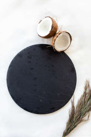 black round stone plate with coconut. top view