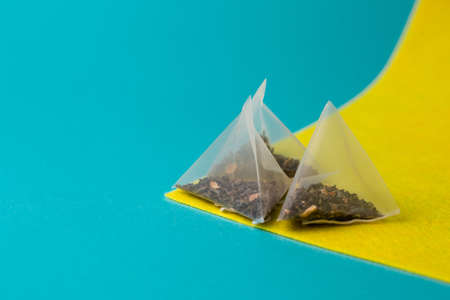 green tea in a pyramid bag on a yellow blue background.の写真素材