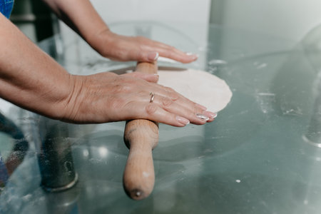 a woman rolls out the dough on the table.の写真素材