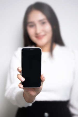 girl in the background with a smartphone in her hands. black phone screen.