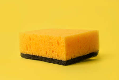 yellow and black sponge for washing dishes on a yellow background.の写真素材