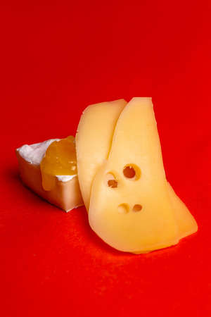 cheese slicing with honey on a red background.の写真素材