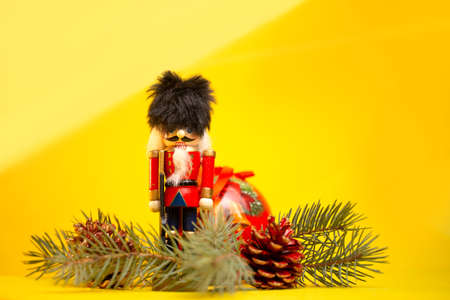 christmas toy nutcracker with festive decorations on a yellow background.の写真素材