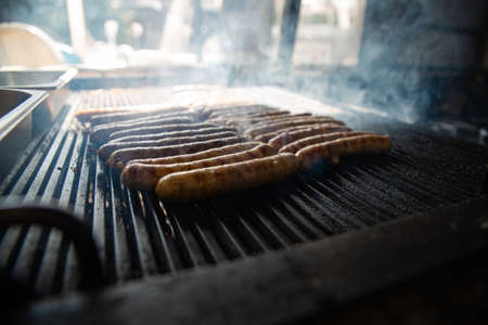 Grilled sausage on the flaming grill. Cooking on coals with smokeの写真素材