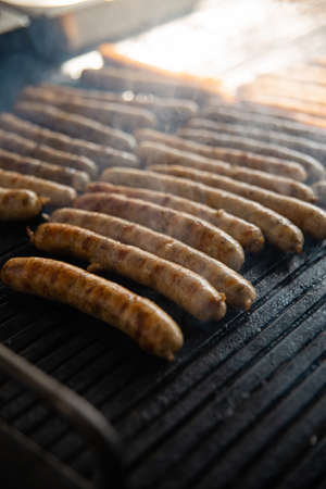 Grilled sausage on the flaming grill. Cooking on coals with smokeの写真素材