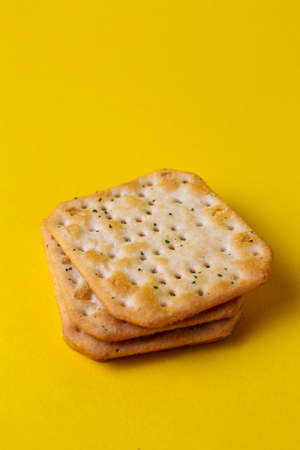 cracker with salt and spices on a yellow backgroundの写真素材