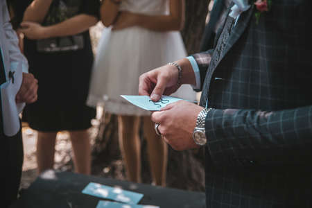 a white envelope in the hands of a man dressed in a suit.の写真素材