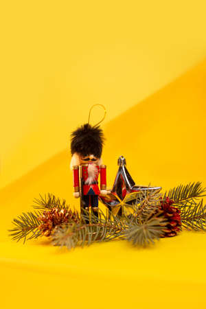 christmas toy nutcracker and New Years decor on a yellow backgroundの写真素材