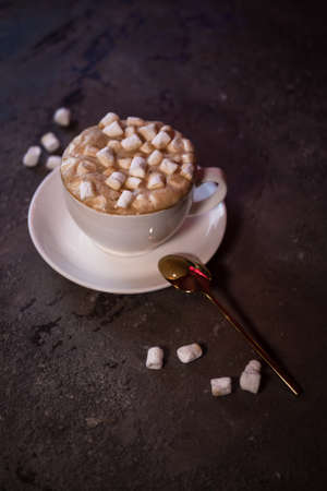 coffee with marshmallows in a white cup on the table.の写真素材