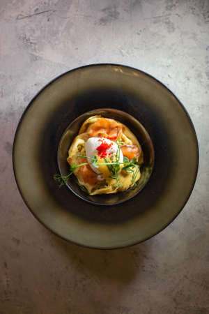Pancake with salmon and cheese. Serving a dish in a plate on a gray background