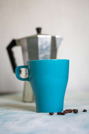 turquoise coffee mug on the background of the coffee makerの写真素材