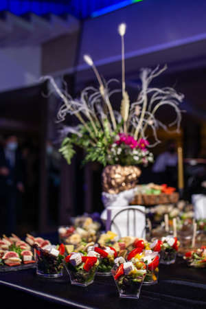 Snacks in plastic cups on the buffet at the event.
